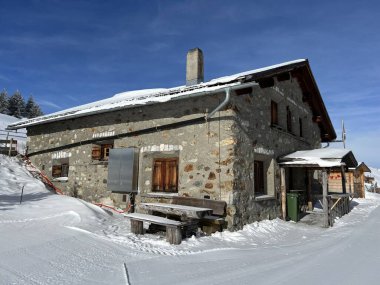 Old traditional swiss rural architecture and alpine livestock farms in the winter ambience of the alpine Swiss tourist resort Arosa - Canton of Grisons, Switzerland (Schweiz)