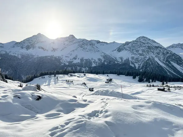 Sabahın erken saatlerinde, İsviçre 'nin ünlü kış beldesi Arosa' nın karlı dağlık tepelerinde yükselen güneş, İsviçre 'nin Grisonlar Kantonu (Schweiz)