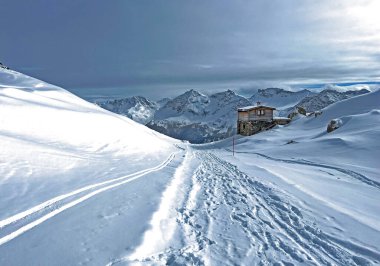 İsviçre Alpleri 'nin taze dağlık kar örtüsünde ve İsviçre' nin Grisonlar Kantonu, İsviçre 'nin turistik tatil beldesi Arosa' nın üzerinde harika kış yürüyüşü patikaları ve izler var.)