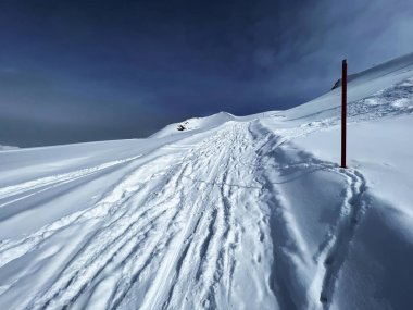 İsviçre Alpleri 'nin taze dağlık kar örtüsünde ve İsviçre' nin Grisonlar Kantonu, İsviçre 'nin turistik tatil beldesi Arosa' nın üzerinde harika kış yürüyüşü patikaları ve izler var.)