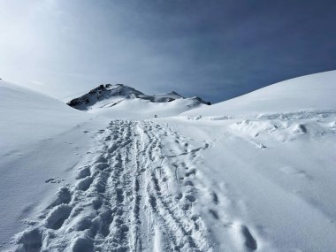 İsviçre Alpleri 'nin taze dağlık kar örtüsünde ve İsviçre' nin Grisonlar Kantonu, İsviçre 'nin turistik tatil beldesi Arosa' nın üzerinde harika kış yürüyüşü patikaları ve izler var.)
