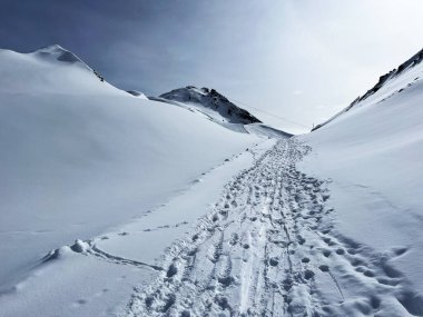 İsviçre Alpleri 'nin taze dağlık kar örtüsünde ve İsviçre' nin Grisonlar Kantonu, İsviçre 'nin turistik tatil beldesi Arosa' nın üzerinde harika kış yürüyüşü patikaları ve izler var.)