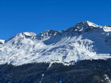 İsviçre 'nin İsviçre Alpleri' ndeki Valbella ve Lenzerheide tatil beldeleri üzerinde güneşli ve karla kaplı alp tepeleri - İsviçre Grisonlar Kantonu, İsviçre (Schweiz)