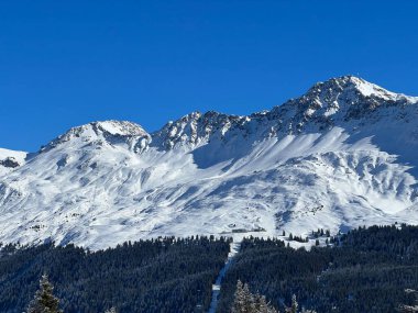 İsviçre 'nin İsviçre Alpleri' ndeki Valbella ve Lenzerheide tatil beldeleri üzerinde güneşli ve karla kaplı alp tepeleri - İsviçre Grisonlar Kantonu, İsviçre (Schweiz)