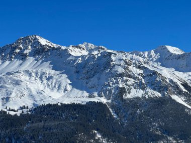 İsviçre 'nin İsviçre Alpleri' ndeki Valbella ve Lenzerheide tatil beldeleri üzerinde güneşli ve karla kaplı alp tepeleri - İsviçre Grisonlar Kantonu, İsviçre (Schweiz)