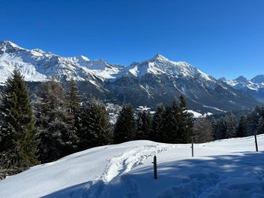 İsviçre 'nin İsviçre Alpleri' ndeki Valbella ve Lenzerheide tatil beldeleri üzerinde güneşli ve karla kaplı alp tepeleri - İsviçre Grisonlar Kantonu, İsviçre (Schweiz)