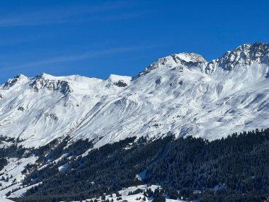 İsviçre 'nin İsviçre Alpleri' ndeki Valbella ve Lenzerheide tatil beldeleri üzerinde güneşli ve karla kaplı alp tepeleri - İsviçre Grisonlar Kantonu, İsviçre (Schweiz)