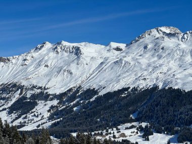 İsviçre 'nin İsviçre Alpleri' ndeki Valbella ve Lenzerheide tatil beldeleri üzerinde güneşli ve karla kaplı alp tepeleri - İsviçre Grisonlar Kantonu, İsviçre (Schweiz)