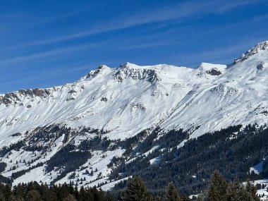 İsviçre 'nin İsviçre Alpleri' ndeki Valbella ve Lenzerheide tatil beldeleri üzerinde güneşli ve karla kaplı alp tepeleri - İsviçre Grisonlar Kantonu, İsviçre (Schweiz)