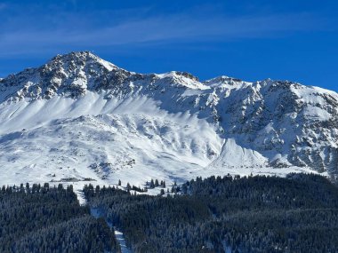 İsviçre 'nin İsviçre Alpleri' ndeki Valbella ve Lenzerheide tatil beldeleri üzerinde güneşli ve karla kaplı alp tepeleri - İsviçre Grisonlar Kantonu, İsviçre (Schweiz)