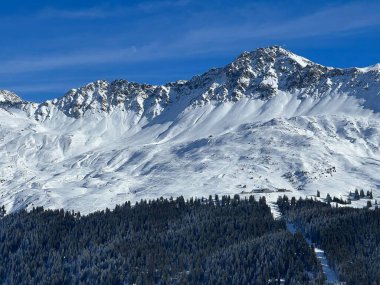 İsviçre 'nin İsviçre Alpleri' ndeki Valbella ve Lenzerheide tatil beldeleri üzerinde güneşli ve karla kaplı alp tepeleri - İsviçre Grisonlar Kantonu, İsviçre (Schweiz)