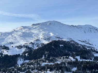 İsviçre 'nin İsviçre Alpleri' ndeki Valbella ve Lenzerheide tatil beldeleri üzerinde güneşli ve karla kaplı alp tepeleri - İsviçre Grisonlar Kantonu, İsviçre (Schweiz)