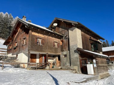 İsviçre Alpleri 'ndeki Valbella ve Lenzerheide tatil beldelerinin kış ortamlarında eski İsviçre kırsal mimarisi ve alp çiftlik hayvanları çiftlikleri (Schweiz)