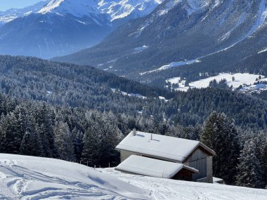 İsviçre Alpleri 'ndeki Valbella ve Lenzerheide tatil beldelerinin kış ortamlarında eski İsviçre kırsal mimarisi ve alp çiftlik hayvanları çiftlikleri (Schweiz)