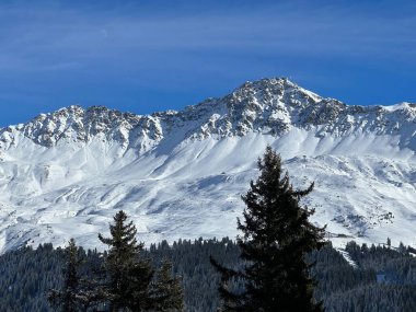 İsviçre 'nin İsviçre Alpleri' ndeki Valbella ve Lenzerheide tatil beldeleri üzerinde güneşli ve karla kaplı alp tepeleri - İsviçre Grisonlar Kantonu, İsviçre (Schweiz)
