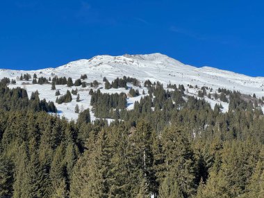 İsviçre 'nin İsviçre Alpleri' ndeki Valbella ve Lenzerheide tatil beldeleri üzerinde güneşli ve karla kaplı alp tepeleri - İsviçre Grisonlar Kantonu, İsviçre (Schweiz)