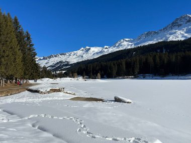 İsviçre 'nin Valbella ve Lenzerheide tatil beldelerindeki donmuş ve karla kaplı Heidsee (Igl Lai) alp gölünde tipik bir kış durağı - İsviçre' nin Grisonlar Kantonu (Schweiz)