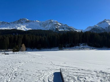 İsviçre 'nin Valbella ve Lenzerheide tatil beldelerindeki donmuş ve karla kaplı Heidsee (Igl Lai) alp gölünde tipik bir kış durağı - İsviçre' nin Grisonlar Kantonu (Schweiz)