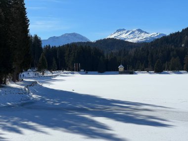 İsviçre 'nin Valbella ve Lenzerheide tatil beldelerindeki donmuş ve karla kaplı Heidsee (Igl Lai) alp gölünde tipik bir kış durağı - İsviçre' nin Grisonlar Kantonu (Schweiz)