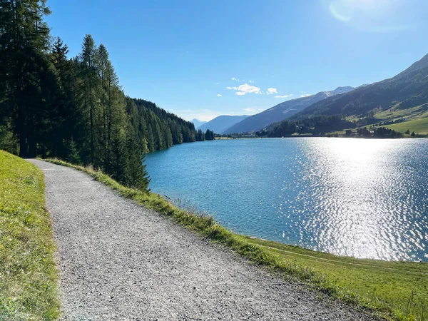 Sports and recreational trail along the alpine lake Davos or loop around mountain Lake Davosersee, Davos Dorf - Canton of Grisons, Switzerland (Kanton Graubuenden, Schweiz)