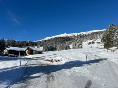 İsviçre Alpleri 'ndeki Valbella ve Lenzerheide tatil beldeleri bölgesinde yürüyüş, yürüyüş, yürüyüş, spor ve dinlenme için mükemmel bir şekilde düzenlenmiş ve temizlenmiş kış patikaları - İsviçre Grison Kantonu, İsviçre (Kanton Graubuenden, Schweiz)