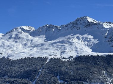 İsviçre 'nin Valbella ve İsviçre Alpleri' ndeki Lenzerheide tatil beldelerinin üzerindeki güzel güneş ışığı ve karlı alp zirveleri - Kanton Grisonlar Kantonu, İsviçre (Kanton Graubuenden, Schweiz)
