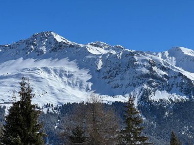 İsviçre 'nin Valbella ve İsviçre Alpleri' ndeki Lenzerheide tatil beldelerinin üzerindeki güzel güneş ışığı ve karlı alp zirveleri - Kanton Grisonlar Kantonu, İsviçre (Kanton Graubuenden, Schweiz)