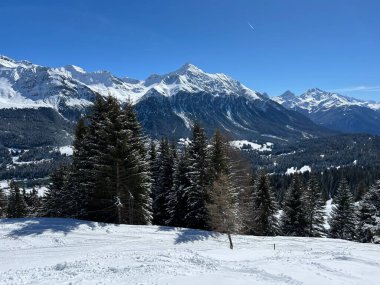 İsviçre 'nin Valbella ve İsviçre Alpleri' ndeki Lenzerheide tatil beldelerinin üzerindeki güzel güneş ışığı ve karlı alp zirveleri - Kanton Grisonlar Kantonu, İsviçre (Kanton Graubuenden, Schweiz)