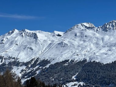 İsviçre 'nin Valbella ve İsviçre Alpleri' ndeki Lenzerheide tatil beldelerinin üzerindeki güzel güneş ışığı ve karlı alp zirveleri - Kanton Grisonlar Kantonu, İsviçre (Kanton Graubuenden, Schweiz)