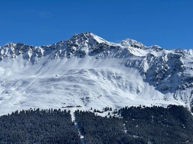 İsviçre 'nin Valbella ve İsviçre Alpleri' ndeki Lenzerheide tatil beldelerinin üzerindeki güzel güneş ışığı ve karlı alp zirveleri - Kanton Grisonlar Kantonu, İsviçre (Kanton Graubuenden, Schweiz)