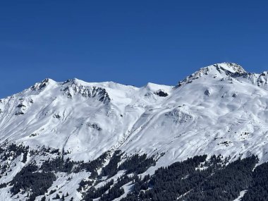 İsviçre 'nin Valbella ve İsviçre Alpleri' ndeki Lenzerheide tatil beldelerinin üzerindeki güzel güneş ışığı ve karlı alp zirveleri - Kanton Grisonlar Kantonu, İsviçre (Kanton Graubuenden, Schweiz)