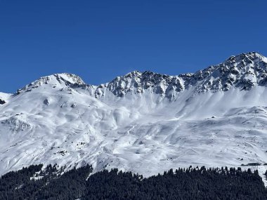 İsviçre 'nin Valbella ve İsviçre Alpleri' ndeki Lenzerheide tatil beldelerinin üzerindeki güzel güneş ışığı ve karlı alp zirveleri - Kanton Grisonlar Kantonu, İsviçre (Kanton Graubuenden, Schweiz)