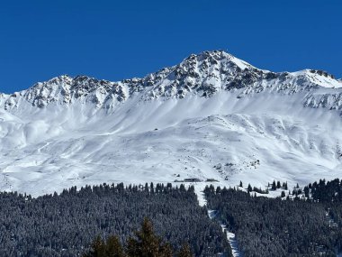 İsviçre 'nin Valbella ve İsviçre Alpleri' ndeki Lenzerheide tatil beldelerinin üzerindeki güzel güneş ışığı ve karlı alp zirveleri - Kanton Grisonlar Kantonu, İsviçre (Kanton Graubuenden, Schweiz)