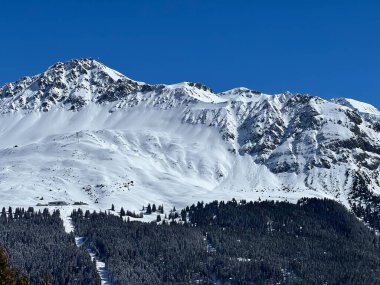 İsviçre 'nin Valbella ve İsviçre Alpleri' ndeki Lenzerheide tatil beldelerinin üzerindeki güzel güneş ışığı ve karlı alp zirveleri - Kanton Grisonlar Kantonu, İsviçre (Kanton Graubuenden, Schweiz)
