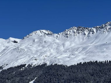 İsviçre 'nin Valbella ve İsviçre Alpleri' ndeki Lenzerheide tatil beldelerinin üzerindeki güzel güneş ışığı ve karlı alp zirveleri - Kanton Grisonlar Kantonu, İsviçre (Kanton Graubuenden, Schweiz)