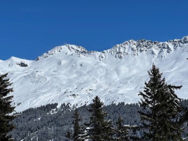 İsviçre 'nin Valbella ve İsviçre Alpleri' ndeki Lenzerheide tatil beldelerinin üzerindeki güzel güneş ışığı ve karlı alp zirveleri - Kanton Grisonlar Kantonu, İsviçre (Kanton Graubuenden, Schweiz)