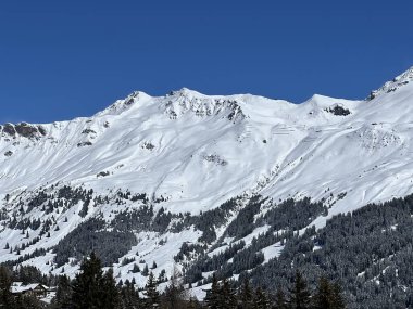İsviçre 'nin Valbella ve İsviçre Alpleri' ndeki Lenzerheide tatil beldelerinin üzerindeki güzel güneş ışığı ve karlı alp zirveleri - Kanton Grisonlar Kantonu, İsviçre (Kanton Graubuenden, Schweiz)