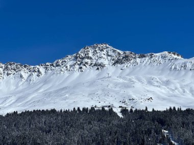 İsviçre 'nin Valbella ve İsviçre Alpleri' ndeki Lenzerheide tatil beldelerinin üzerindeki güzel güneş ışığı ve karlı alp zirveleri - Kanton Grisonlar Kantonu, İsviçre (Kanton Graubuenden, Schweiz)