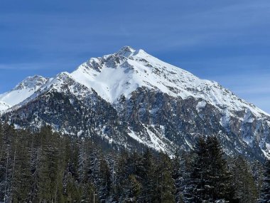 İsviçre 'nin Valbella ve İsviçre Alpleri' ndeki Lenzerheide tatil beldelerinin üzerindeki güzel güneş ışığı ve karlı alp zirveleri - Kanton Grisonlar Kantonu, İsviçre (Kanton Graubuenden, Schweiz)