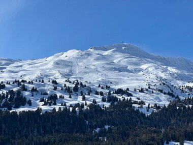İsviçre 'nin Valbella ve İsviçre Alpleri' ndeki Lenzerheide tatil beldelerinin üzerindeki güzel güneş ışığı ve karlı alp zirveleri - Kanton Grisonlar Kantonu, İsviçre (Kanton Graubuenden, Schweiz)