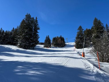 İsviçre Alpleri 'ndeki dağlık İsviçre turisti Valbella ve Lenzerheide' nin tepelerindeki karlı yamaçlarda güneş ışığı ve gölgenin büyülü oyunu - İsviçre 'nin Grison Kantonu, İsviçre (Kanton Graubuenden, Schweiz)
