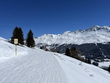 İsviçre Alpleri 'ndeki dağlık İsviçre turisti Valbella ve Lenzerheide' nin tepelerindeki karlı yamaçlarda güneş ışığı ve gölgenin büyülü oyunu - İsviçre 'nin Grison Kantonu, İsviçre (Kanton Graubuenden, Schweiz)