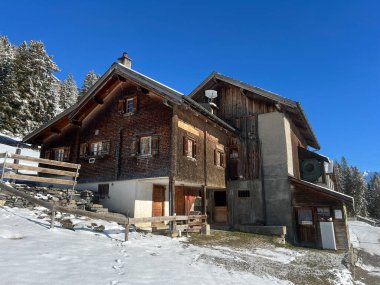 İsviçre Alpleri 'ndeki Valbella ve Lenzerheide tatil beldelerinin kış ortamlarında eski İsviçre kırsal mimarisi ve alp çiftlik hayvanları çiftlikleri - İsviçre Grison Kantonu, İsviçre (Kanton Graubuenden, Schweiz)