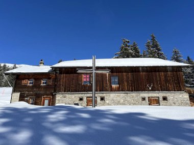 İsviçre Alpleri 'ndeki Valbella ve Lenzerheide tatil beldelerinin kış ortamlarında eski İsviçre kırsal mimarisi ve alp çiftlik hayvanları çiftlikleri - İsviçre Grison Kantonu, İsviçre (Kanton Graubuenden, Schweiz)