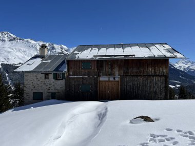İsviçre Alpleri 'ndeki Valbella ve Lenzerheide tatil beldelerinin kış ortamlarında eski İsviçre kırsal mimarisi ve alp çiftlik hayvanları çiftlikleri - İsviçre Grison Kantonu, İsviçre (Kanton Graubuenden, Schweiz)