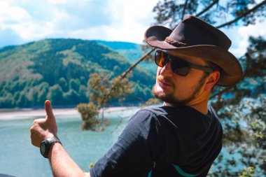 Bir adam dinleniyor ve katlanır bir sandalyede oturup dağlardaki mesafeye bakıyor. Lake, Carpatians dağları Ukrayna