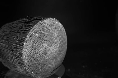 Kullanılmış, tahrip edilmiş, deformasyonla. Zararlı emisyon filtresi, araçtan katalizör. Detaylı olarak kapat. Değerli metaller içeren malzeme. Egzoz sistemi susturucusu. Siyah arkaplan.