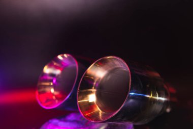 Krom, aracın egzoz sisteminin çift borusu. Araba ayarı için iyi bir ayrıştırıcı. Seçici odaklanma, karanlık arka plan. Boşluğu kopyala