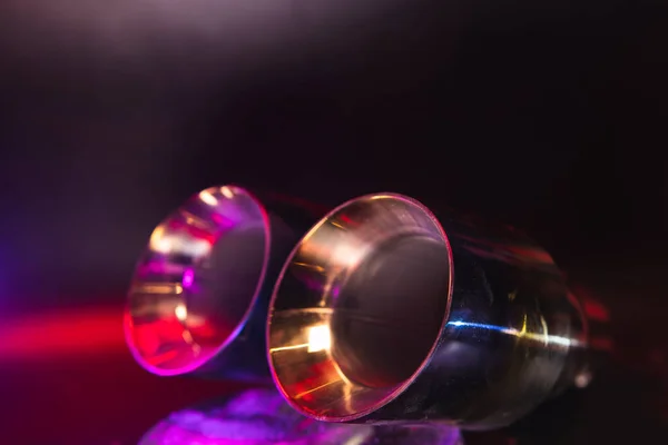 Krom, aracın egzoz sisteminin çift borusu. Araba ayarı için iyi bir ayrıştırıcı. Seçici odaklanma, karanlık arka plan. Boşluğu kopyala