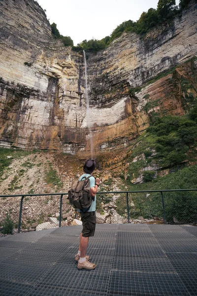 Man Hiker Backpacker Stands Looks Kinchkha Waterfall Georgia Vertical Photo — Stockfoto